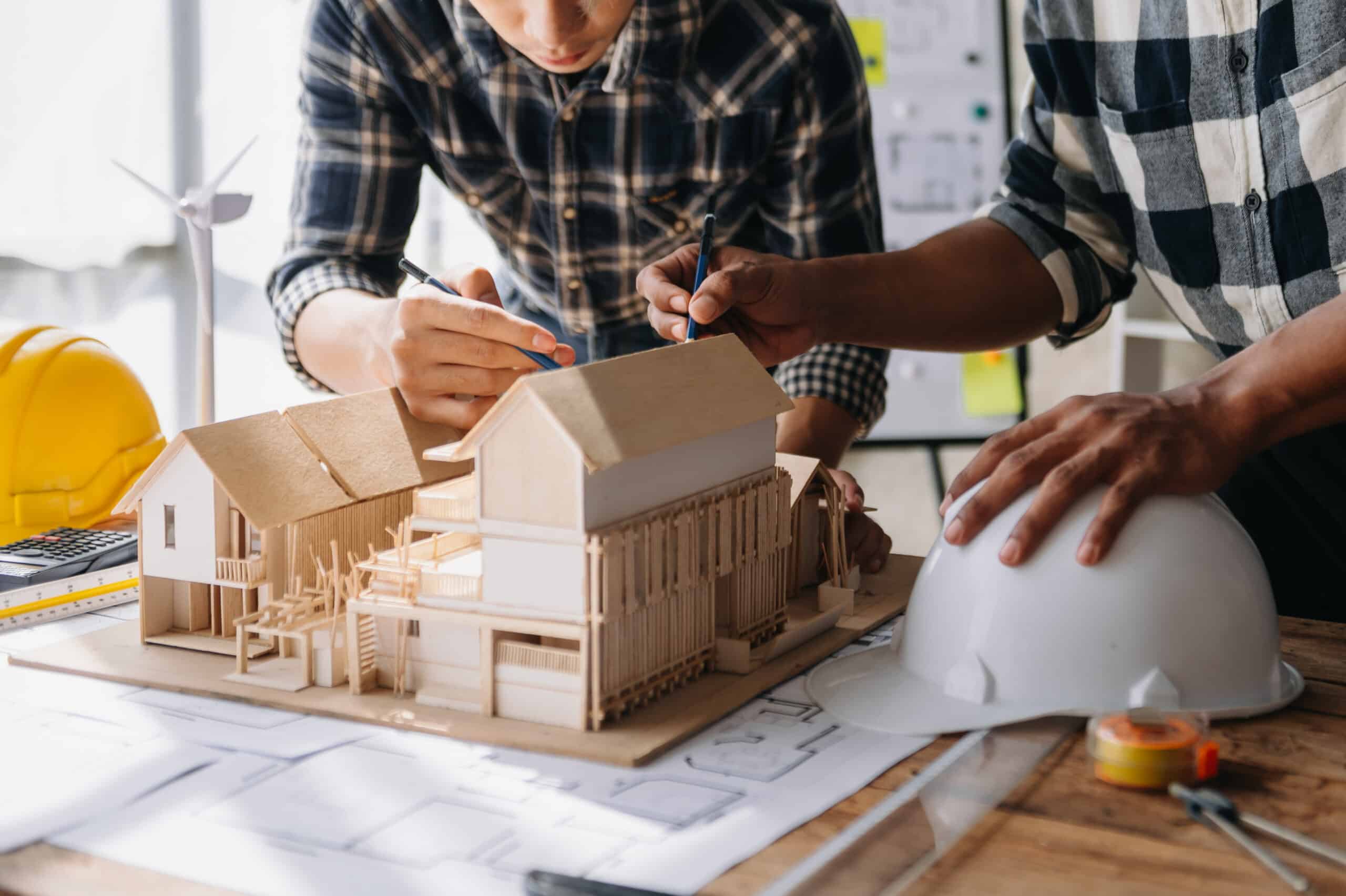 Close up shot of scale model house on table with architects